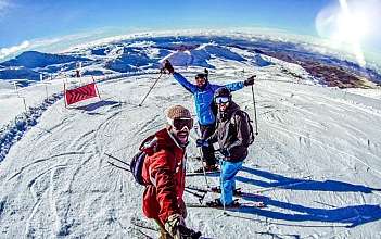 Skifahrer auf schneebedecktem Berg Drei Skifahrer posieren auf einem schneebedeckten Hang.