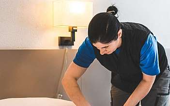 Zimmermädchen macht das Bett Eine Person macht das Bett in einem Hotelzimmer.