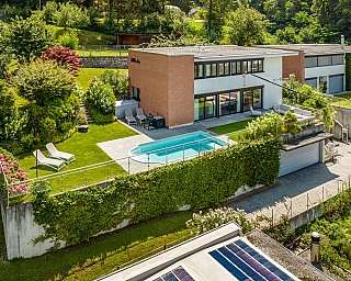 Luftaufnahme einer modernen Villa mit Garten und Swimmingpool.