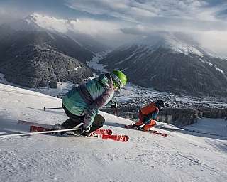 Two skiers navigating a snowy mountain landscape.