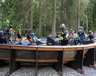 Groupe d&#039;enfants sur un parcours de vélo en forêt.