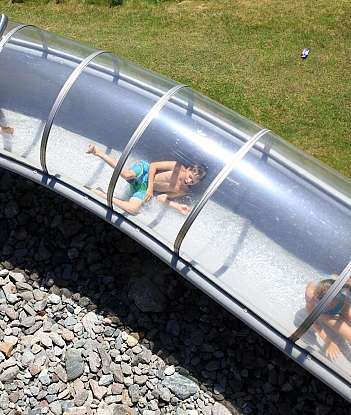 Kids enjoying a water slide on a sunny day.