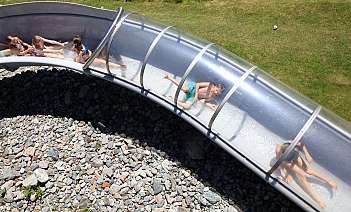 Des enfants s&#039;amusent sur un toboggan aquatique transparent.