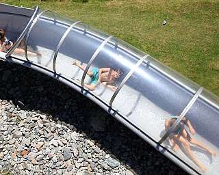 Enfants s&#039;amusant sur un toboggan aquatique transparent.