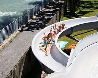 Gruppe von Kindern auf einer Wasserrutsche im Freien.