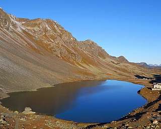Vue panoramique d&#039;un lac entouré de montagnes et d&#039;une route.