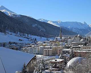 Paysage enneigé avec des montagnes et des bâtiments en station de ski.
