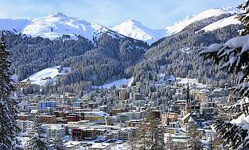 Aerial view of a picturesque village surrounded by mountains and greenery.