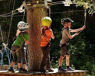 Groupe d&#039;enfants préparant une tyrolienne en pleine nature.