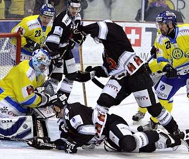 Spieler kämpfen um den Puck vor dem Torwart.
