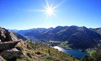 Paysage montagneux avec un lac et un village en contrebas.