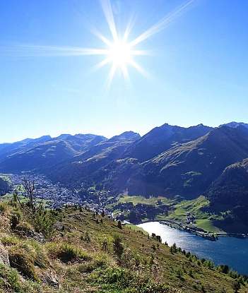 Panoramaansicht der Berge und eines Sees bei sonnigem Wetter.