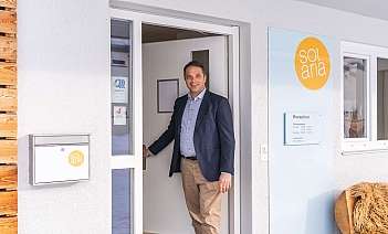 Un homme souriant se tient à la porte de Solaria.