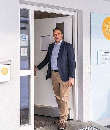Un homme souriant se tient à la porte de Solaria.