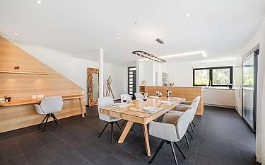 Helles Esszimmer mit Holzdetails und eleganten Stühlen.