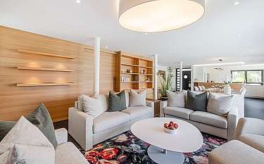 Gemütliches Wohnzimmer mit Sofas, Tisch und Holzregalen.