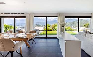 Helle Wohnküche mit Blick auf die Berge und Terrasse.