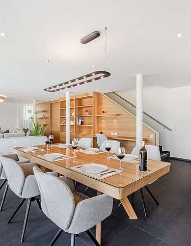 Helles Esszimmer mit Holz-Esstisch und stilvollen Stühlen.
