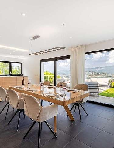 Helles Esszimmer mit Blick auf die Berge und Terrasse.