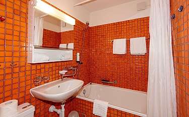 Kompaktes Badezimmer mit Badewanne und Waschbecken.