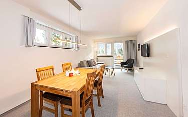 Modernes Wohnzimmer mit Esstisch und gemütlicher Sitzecke.