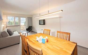 Modernes Wohnzimmer mit Esstisch und Balkonblick.