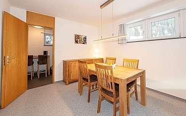 Gemütliches Esszimmer mit Tisch, Stühlen und Fenster.