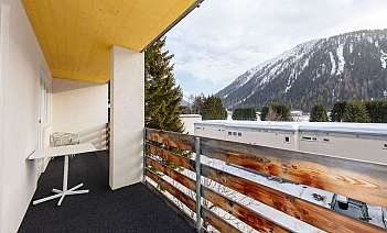 Balkon mit Bergblick Balkon mit Tisch und Stühlen, Blick auf schneebedeckte Berge.