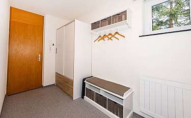 Ein Flur mit einer Garderobe, einer Sitzbank und einem Fenster.