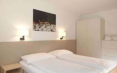 Gemütliches Schlafzimmer mit Doppelbett und modernem Schrank.