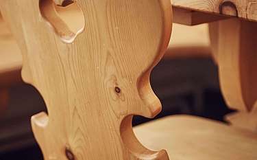 Detailaufnahme eines Holzstuhls mit herzförmigem Ausschnitt.
