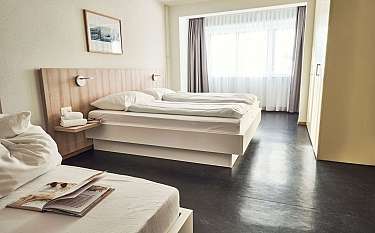 Modernes Hotelzimmer mit zwei Betten und Fenster.