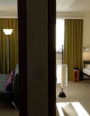 A split view of a hotel room with a living area and bedroom.