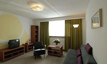 A stylish living room with green curtains and contemporary furniture.