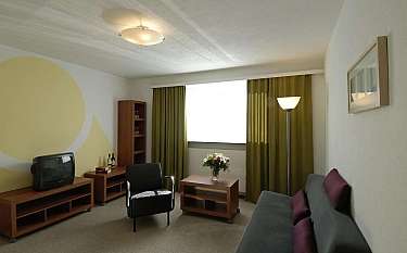 A stylish living room with green curtains and contemporary furniture.