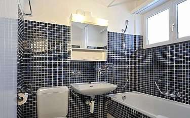Compact bathroom featuring a toilet, sink, and bathtub.
