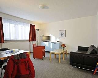 Bright living room with sofa, table, and curtains.