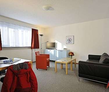 Bright living room with sofa, table, and TV.