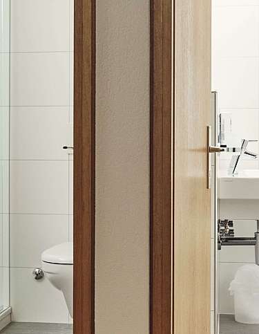 View of a bathroom with a shower, toilet, and sink.