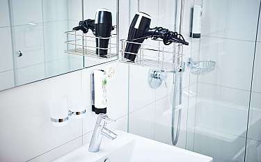 A sleek bathroom featuring a hairdryer and toiletries.