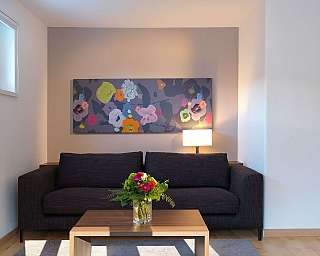 A stylish living room with a floral painting and a coffee table.