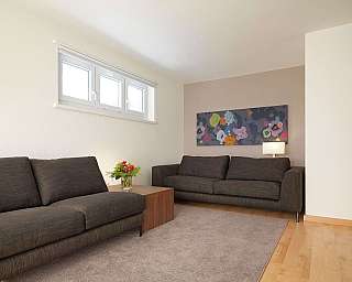 Contemporary living room featuring two sofas and floral wall art.