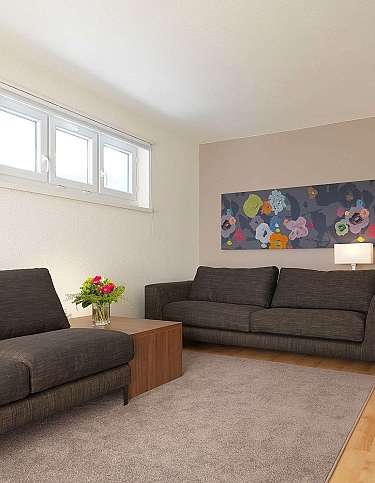 Spacious living room with two sofas and floral artwork.