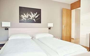Modernes Schlafzimmer mit zwei Einzelbetten und Kunstwerk an der Wand.