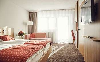 Chambre d&#039;hôtel avec lit, canapé et télévision.