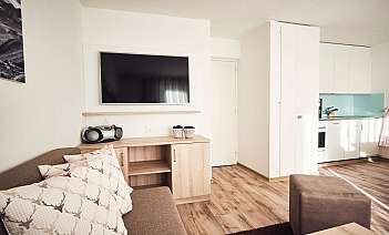 Moderne Wohnküche mit Fernseher Helle Wohnküche mit Sofa, Fernseher und Küchenzeile.