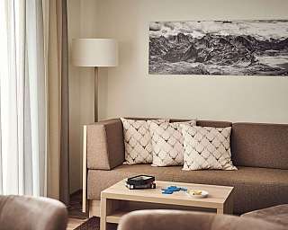 Ein modernes Wohnzimmer mit einem Sofa, Kissen und einem Tisch.