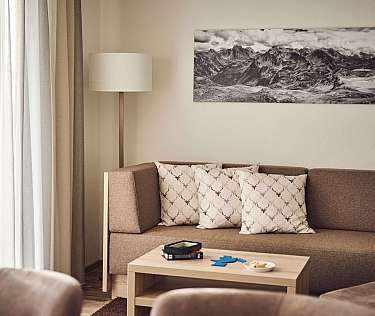Ein modernes Wohnzimmer mit einem Sofa, Kissen und einem Tisch.