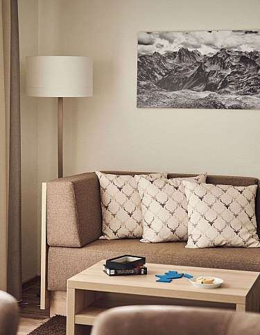 Ein modernes Wohnzimmer mit einem Sofa, Kissen und einem Tisch.