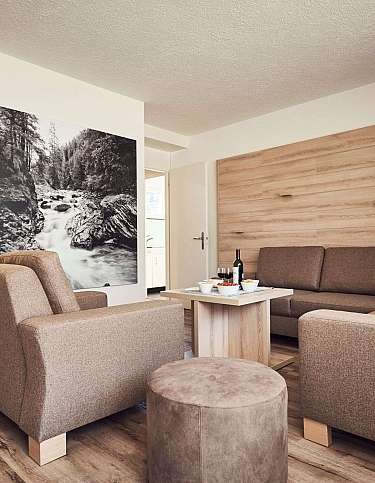Modernes Wohnzimmer mit Sofas, Tisch und Kunstwerk an der Wand.